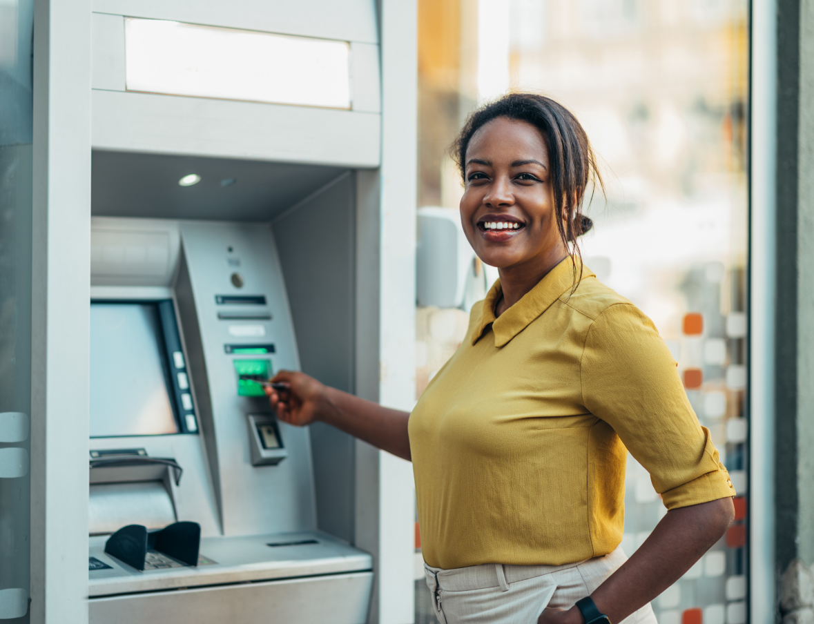 african-american-woman-using-an-atm-machine-and-a-2023-11-27-05-07-53-utc 1